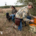 Yeti Hopper Flip 18 Personal Cooler - A tan cooler with a black zipper and handle, sitting on a wooden dock near a body of water.