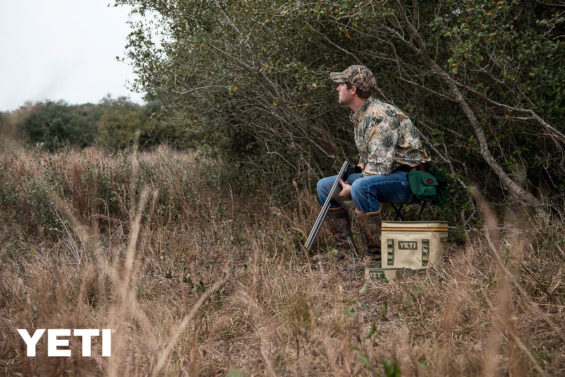 Yeti Hopper Flip 18 Personal Cooler - A tan cooler with a black handle and zipper, sitting on a wooden dock by the water.