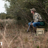 Yeti Hopper Flip 18 Personal Cooler - A tan cooler with a black handle and zipper, sitting on a wooden dock by the water.