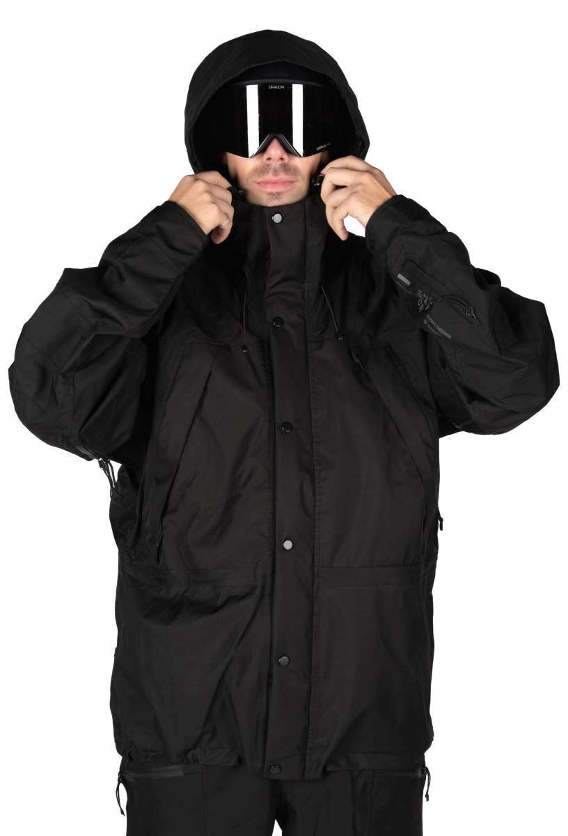 Endeavor 2 Layer Shelter Shell Jacket 2024 - A black jacket with a hood, featuring two zippered pockets on either side and a front zipper closure.