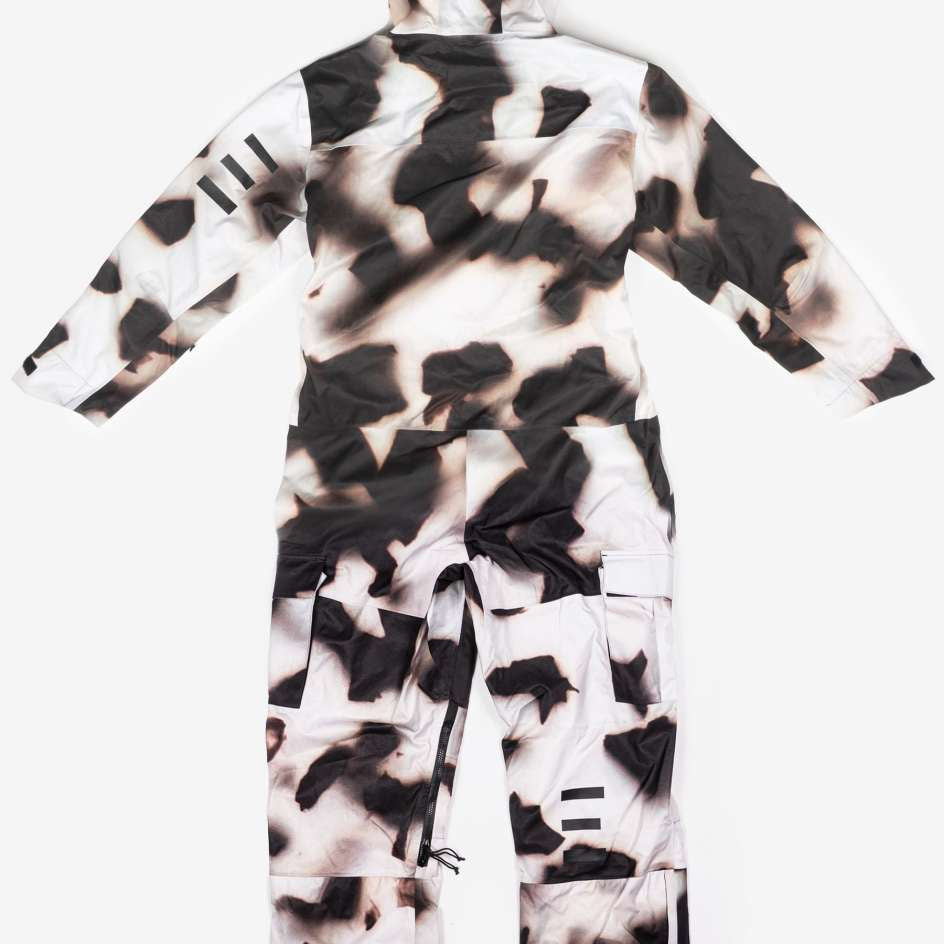 Endeavor 3L Shelter One Piece Suit 2024 - A black and white snowsuit with a cow print design, featuring a hood and zippered pockets on the front.