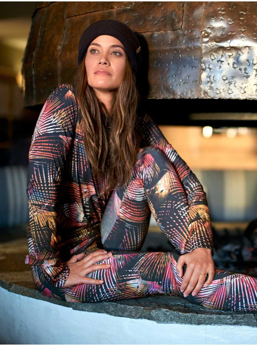 Roxy Women's Daybreak Technical Baselayer Leggings 2020 - A pair of black leggings with a palm tree print in shades of pink, orange, and white.