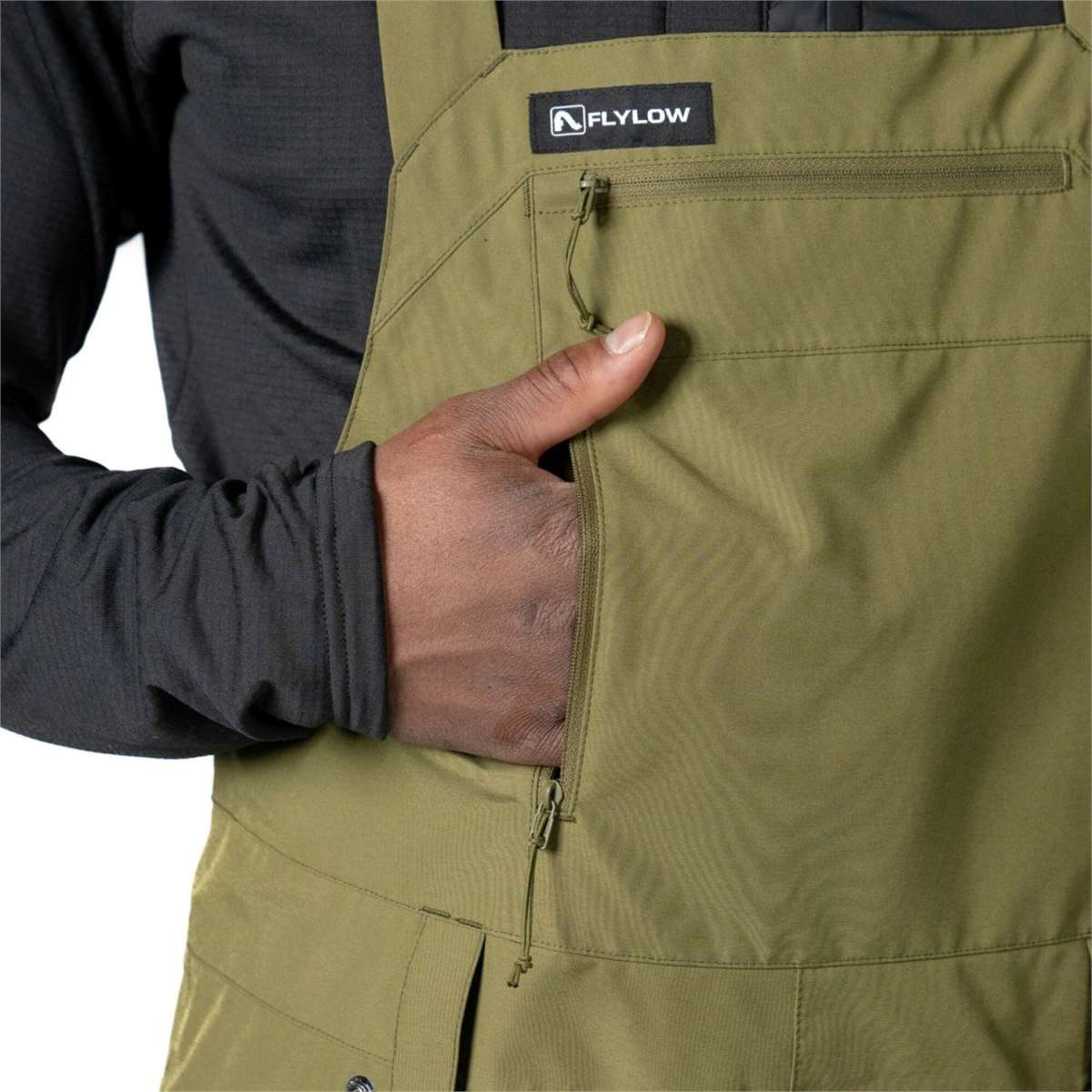 Flylow Firebird Shell Bib Pants 2024 - Olive green bib pants with a zippered fly and adjustable side straps.