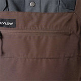 Flylow Firebird Shell Bib Pants 2024 - A pair of brown bib pants with a black patch on the left side featuring white lettering that reads "FLYLOW".