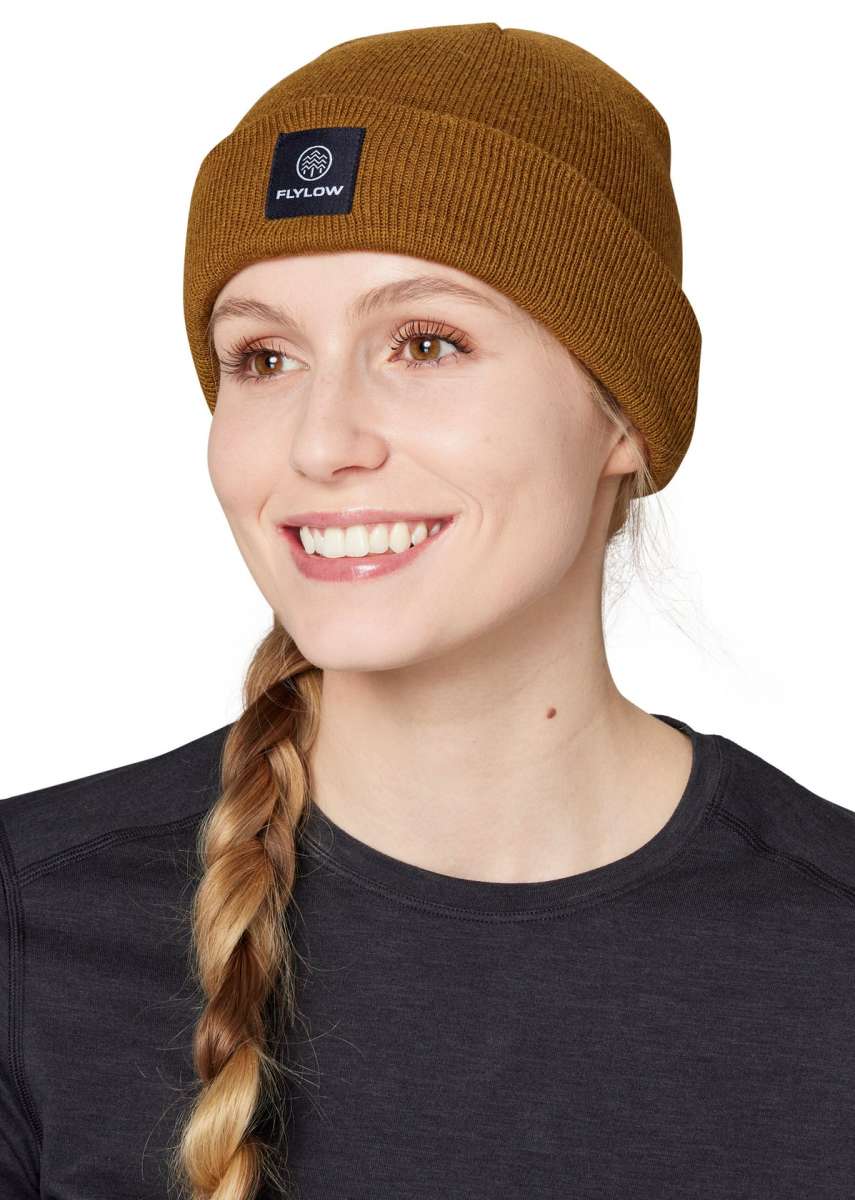 Flylow Longshoreman Beanie 2024 - A brown beanie with a black patch on the front featuring a white logo and the word "FLYLOW" in white letters.
