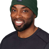Flylow Longshoreman Beanie 2024 - A dark green beanie with a black patch on the front featuring a white logo and the word "FLYLOW" in white letters.
