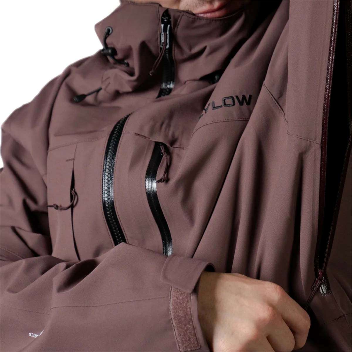 Flylow Quantum Pro Shell Jacket 2024 - A brown jacket with a black zipper and Flylow logo on the left chest.