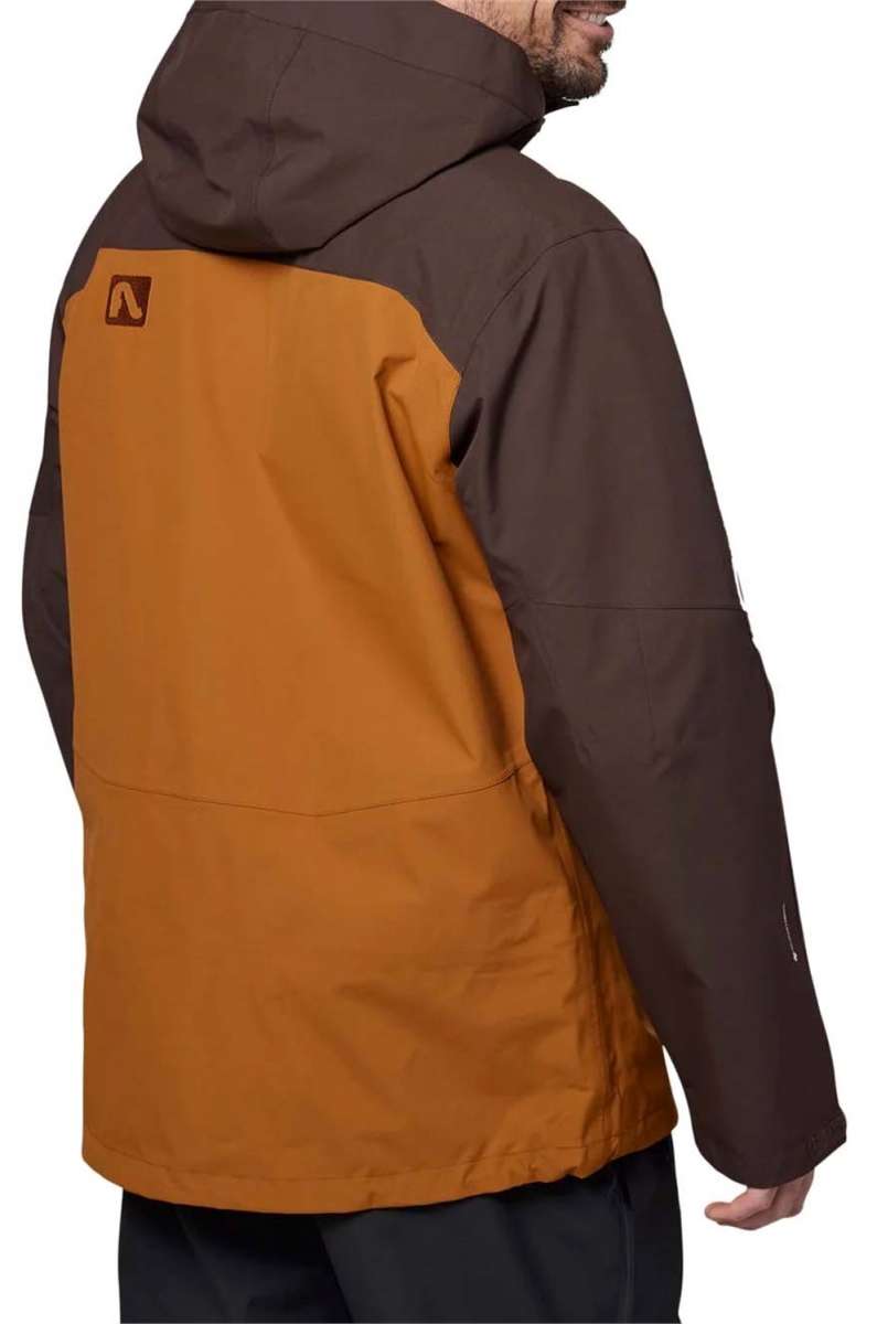 Flylow Quantum Pro Shell Jacket 2024 - A brown jacket with a black hood and chest pocket, featuring a flylow logo on the left sleeve.