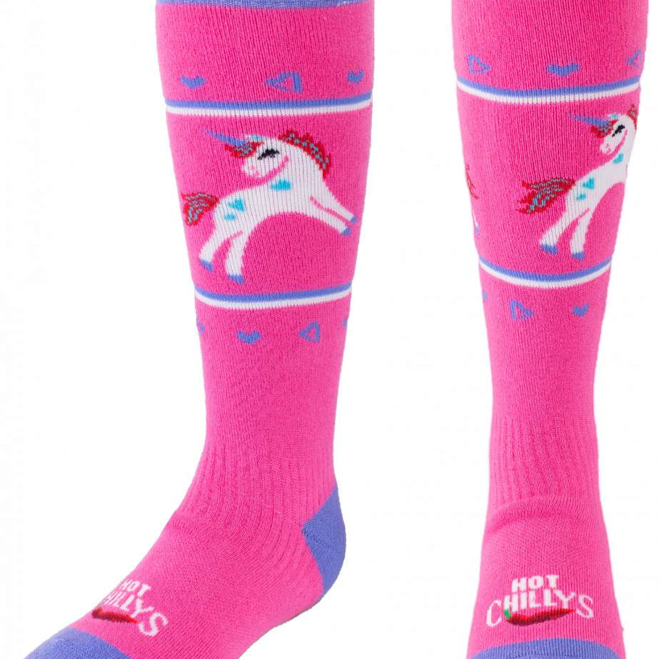 Hot Chillys - Youths magical friend mid volume sock with a unicorn design on a pink background.