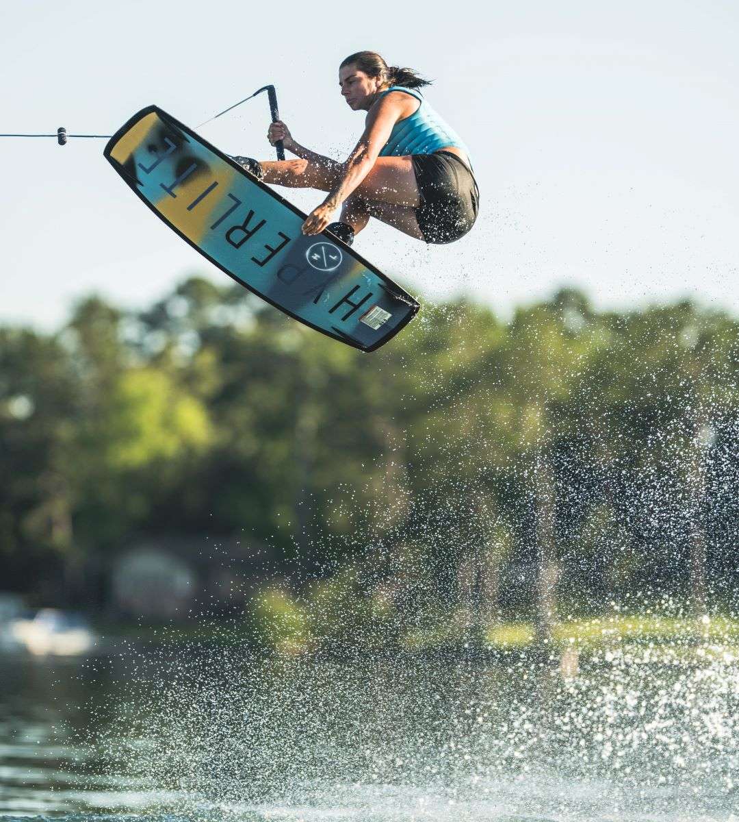 Hyperlite Women's Cadence Wakeboard 2022 - A blue and yellow wakeboard with a white logo on top.