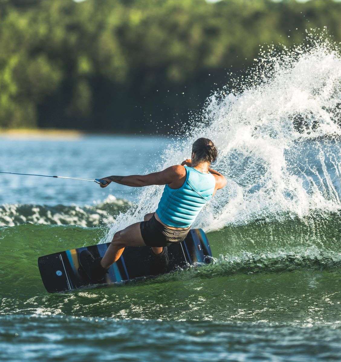 Hyperlite Women's Cadence Wakeboard 2022 - A black and blue wakeboard with a white logo on top.