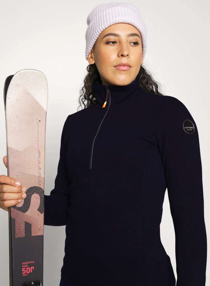 Icepeak Ladies Evansdale 1/4 Zip Top 2022-2023 - A navy-blue zip-up top with a high collar and zipper that runs from the neck to the chest, worn by a woman.