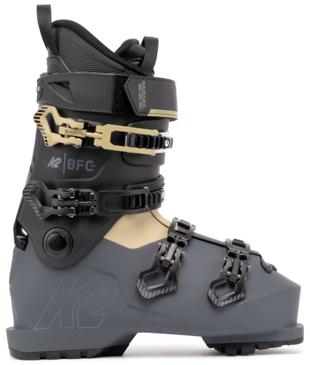 The image shows a pair of K2 BFC 90 GW ski boots for the 2021-2022 season. The boots are black and gray with a white sole, featuring a buckle closure system and straps for adjusting the fit. They have a sturdy design, suitable for winter sports activities such as skiing or snowboarding.