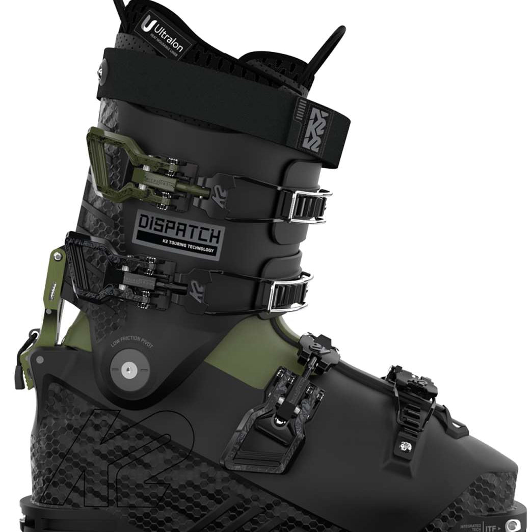 The image shows a pair of K2 Dispatch Alpine Touring Ski Boots for the year 2023. These boots are designed for alpine touring and feature a camouflage pattern on the upper part, with black straps and buckles. The boots have a greenish-gray color scheme and appear to be made of durable materials suitable for skiing in various terrains.