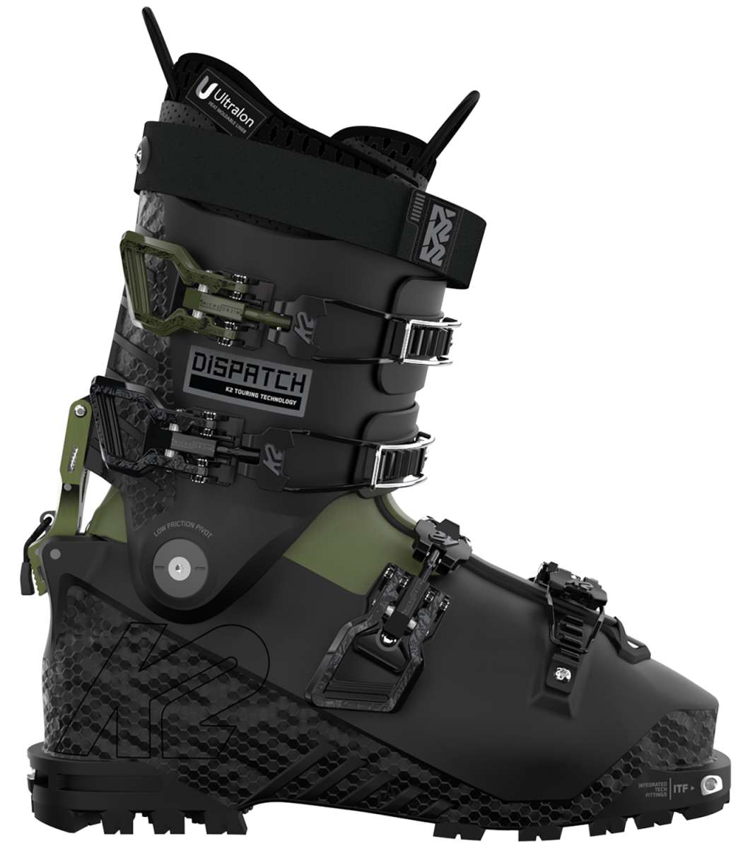 The image shows a pair of K2 Dispatch Alpine Touring Ski Boots for the year 2023. These boots are designed for alpine touring and feature a camouflage pattern on the upper part, with black straps and buckles. The boots have a greenish-gray color scheme and appear to be made of durable materials suitable for skiing in various terrains.