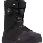 The image shows a pair of black snowboard boots with a white logo on the side. The boots have a thick, insulated design and are equipped with a buckle closure system for secure fit. They also feature a sturdy rubber sole for grip and durability.