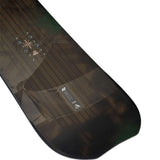 K2 Passport snowboard, black with a subtle graphic design, rests on a snowy surface.