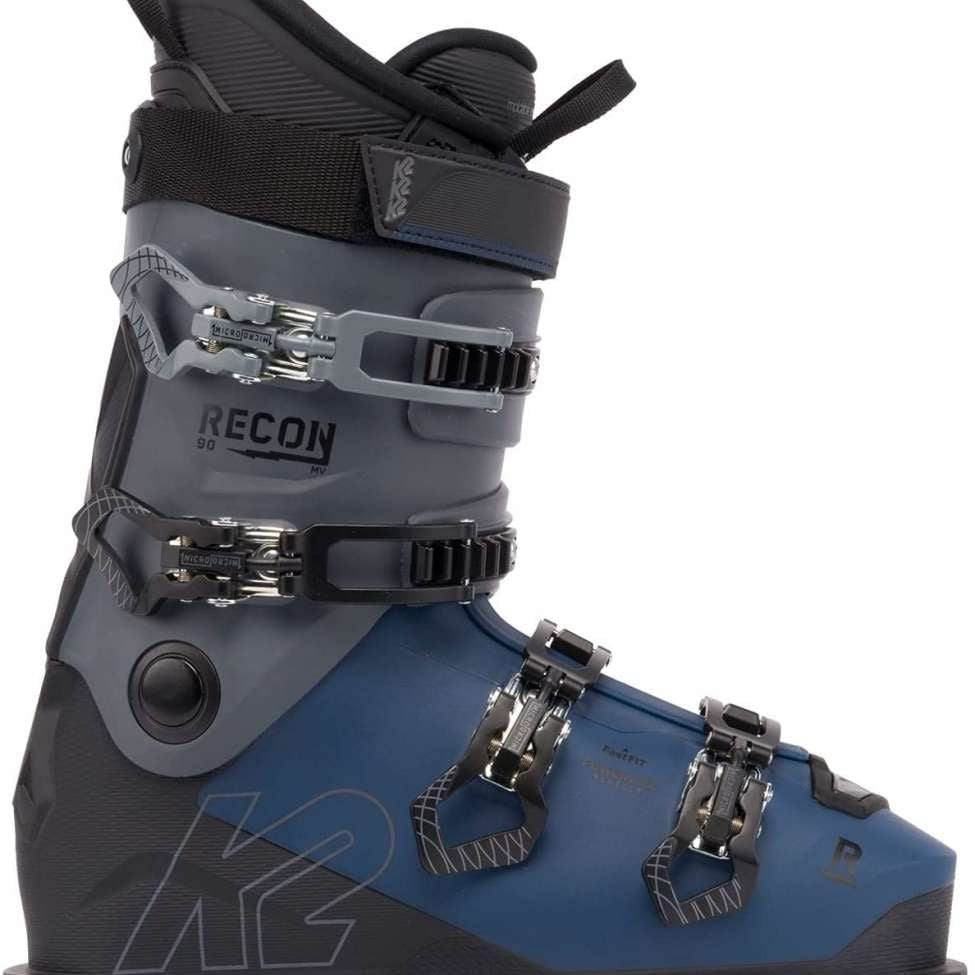 The image shows a pair of K2 Recon 90 MV ski boots for the year 2023. The boots are blue and black with silver buckles, straps, and hardware. They have a sturdy design with multiple adjustment points to ensure a secure fit.