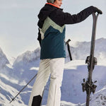 Killtec Ladies KSW 83 Peak Insulated Jacket - A dark blue jacket with a light green chevron pattern on the back, worn by a model in front of snowy mountains.
