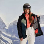 Killtec Ladies KSW 83 Peak Insulated Jacket - A black jacket with a green and white chevron pattern on the chest, worn by a woman in front of snowy mountains.