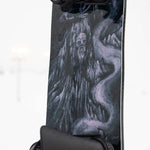 Lib Tech Skunk Ape Camber Snowboard 2025 - Black snowboard with a white and blue abstract design on top of a snowy mountain landscape.