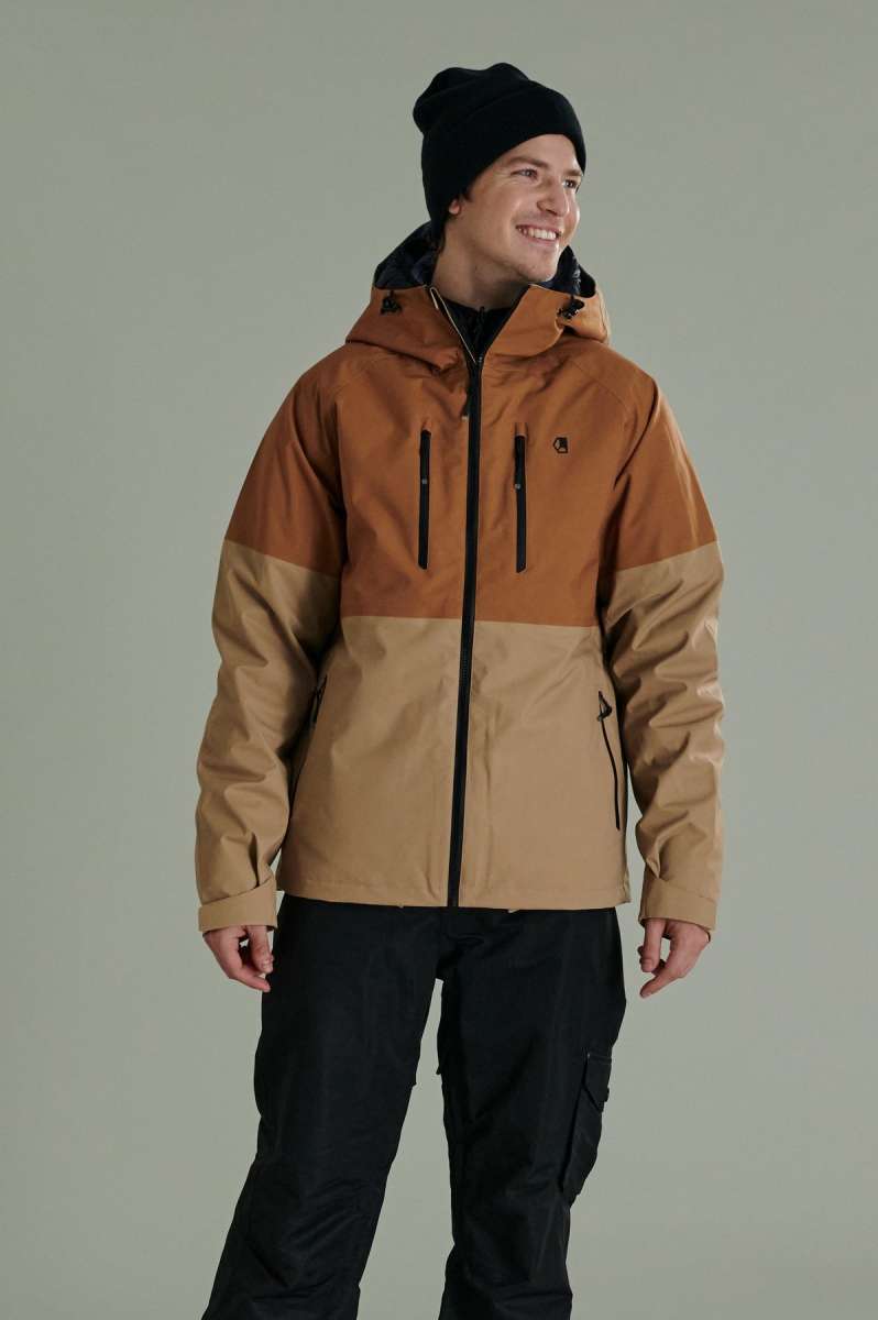 Liquid Anton Pro Stretch Jacket - A tan jacket with a black zipper, two zippered pockets on the front and one on the left arm.