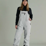 Liquid Ladies Celeste Insulated Bib 2022-2023 - A bib-style snowsuit with a black and white patterned design, featuring a zippered front and adjustable straps.