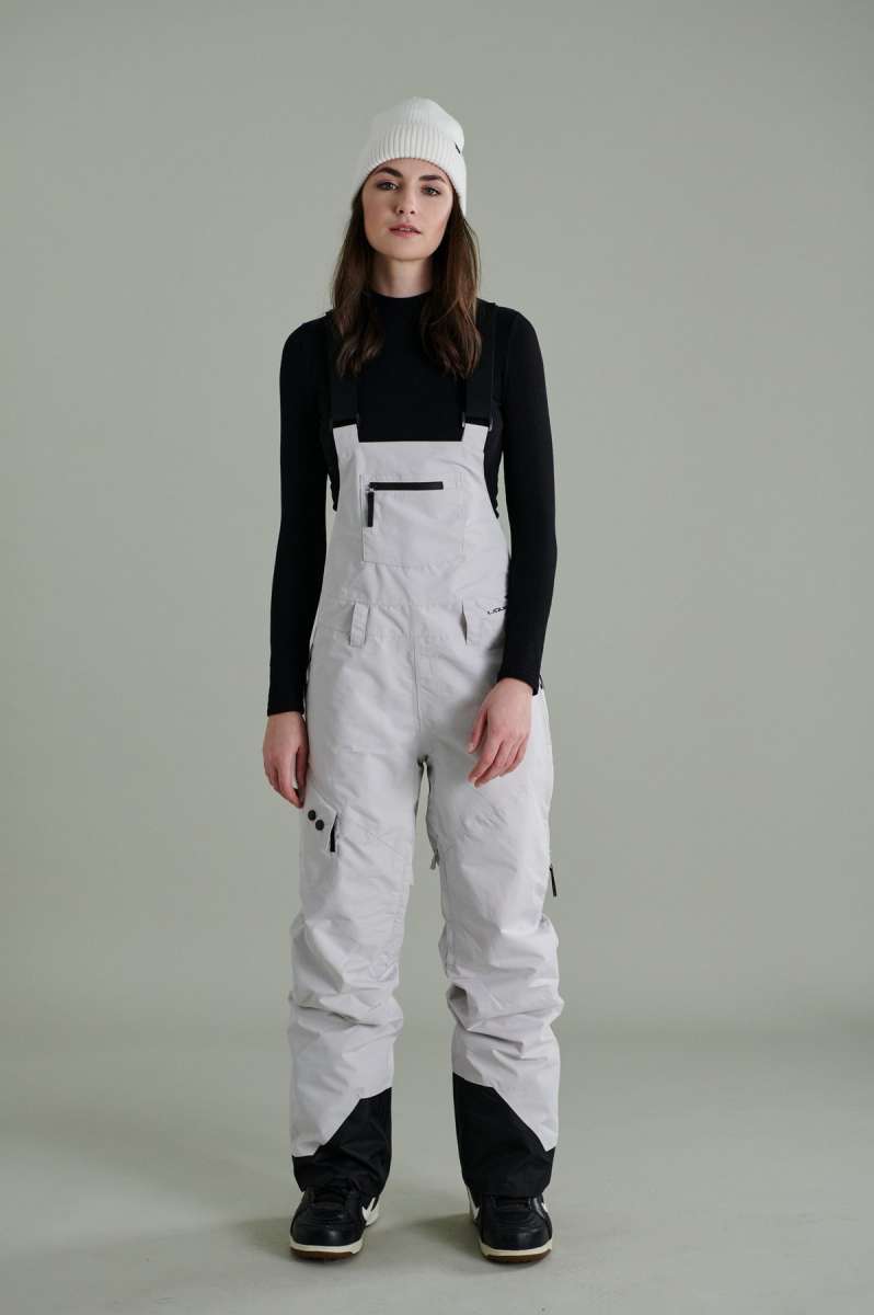 Liquid Ladies Celeste Insulated Bib 2022-2023 - A bib-style snowsuit with a black and white color scheme, featuring a subtle pattern of small, dark dots on the upper portion.