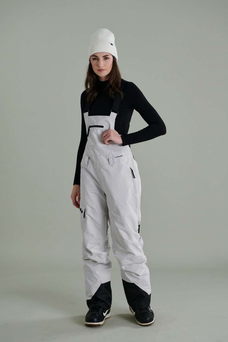 Liquid Ladies Celeste Insulated Bib 2022-2023 - A black and white bib-style snowsuit with a zippered front, adjustable straps, and two side pockets.