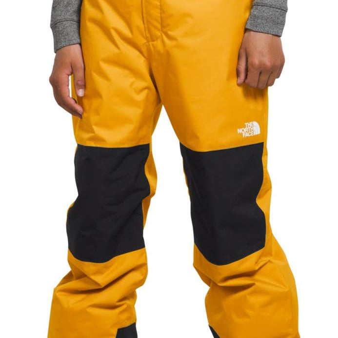 North Face Boys Freedom Insulated Pant 2024 - A pair of yellow and black insulated ski pants with a white logo on the left thigh.