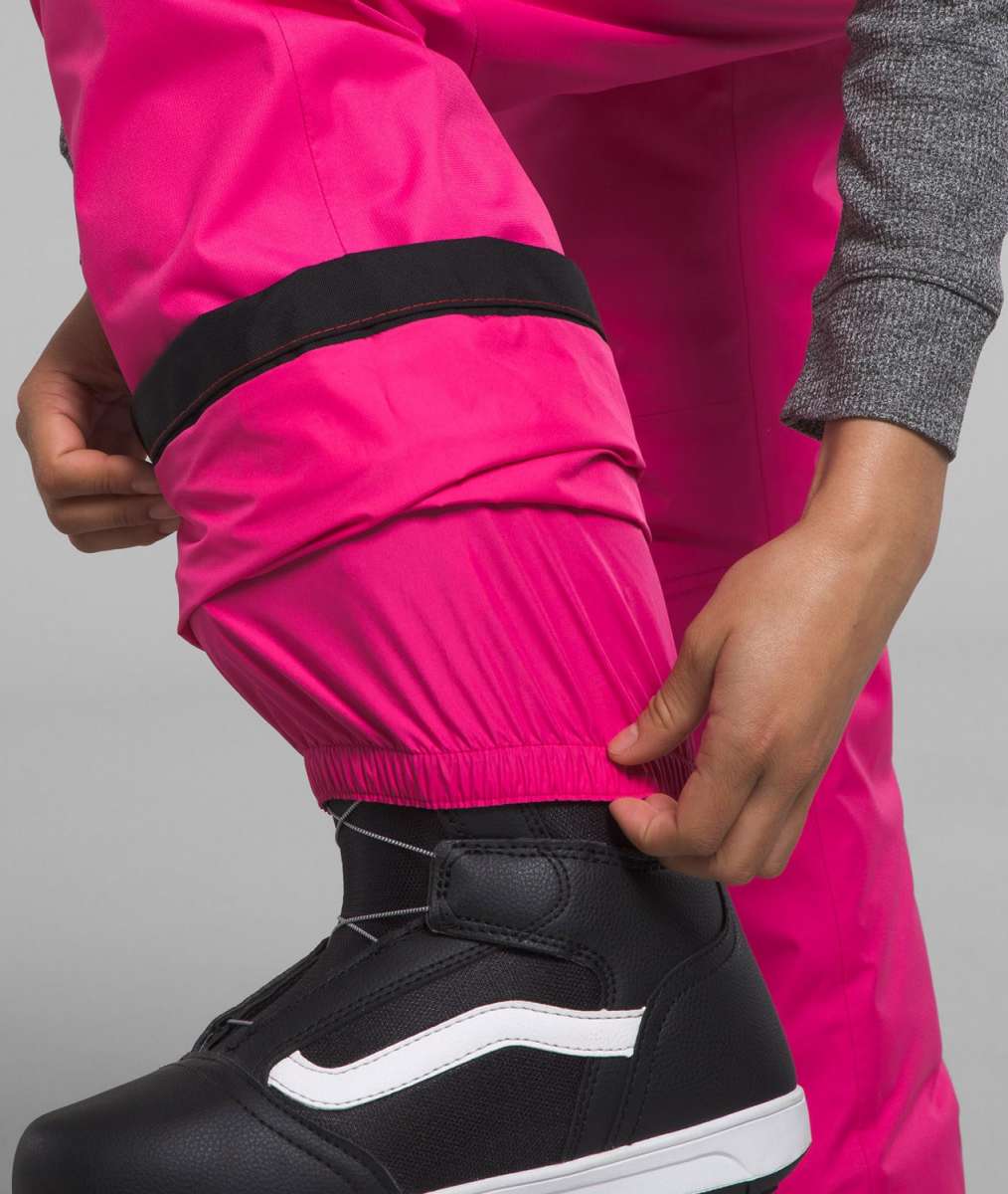 North Face Girls Freedom Insulated Pant 2024 - A pair of bright pink snow pants with black trim and a black elastic waistband.