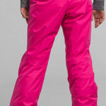 North Face Girls Freedom Insulated Pant 2024 - A pair of bright pink snow pants with a black waistband and cuffs, featuring a prominent "THE NORTH FACE" logo in white on the back.