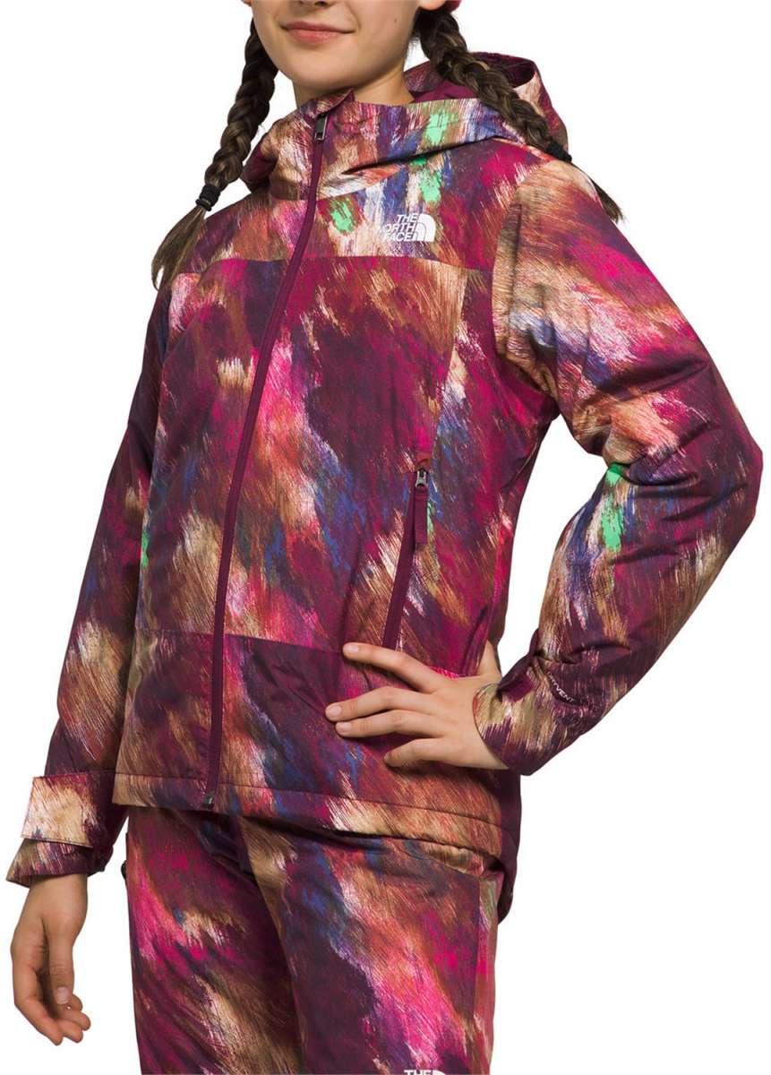 North Face Girls Freedom Insulated Jacket - A young girl with long brown hair in braids is wearing a purple jacket with a colorful abstract pattern of pink, blue, and tan brush strokes.