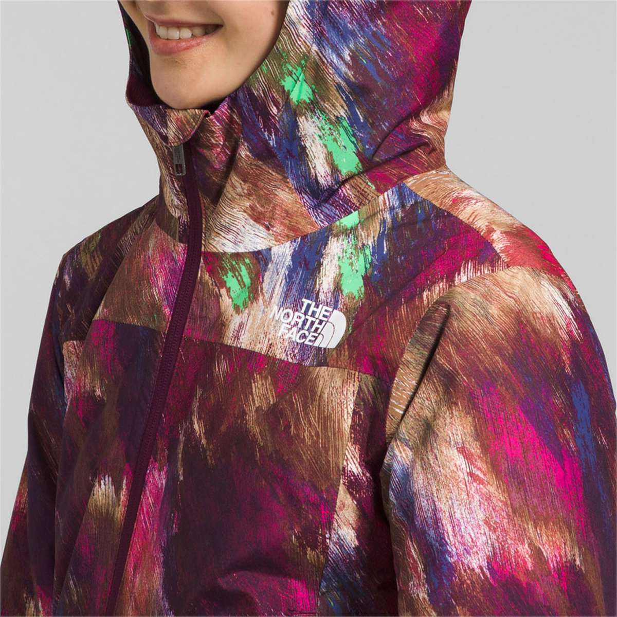 North Face Girls Freedom Insulated Jacket 2024 - A multicolored jacket with a hood, featuring a white logo on the chest and a zipper down the front.