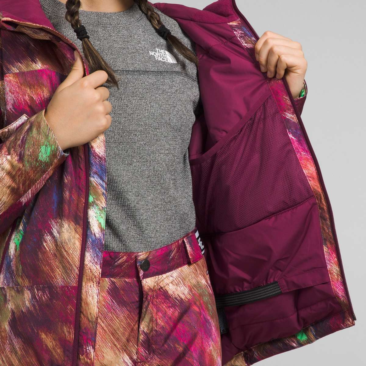 North Face Girls Freedom Insulated Jacket 2024 - A dark-colored jacket with a white logo on the chest and a zipper down the front.