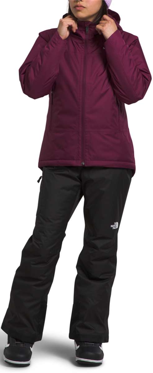 North Face Girls Freedom Insulated Jacket - A young girl wearing a purple jacket with a hood, zipped up to her neck.