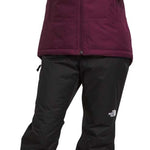 North Face Girls Freedom Insulated Jacket - A young girl wearing a purple jacket with a hood, zipped up to her neck.