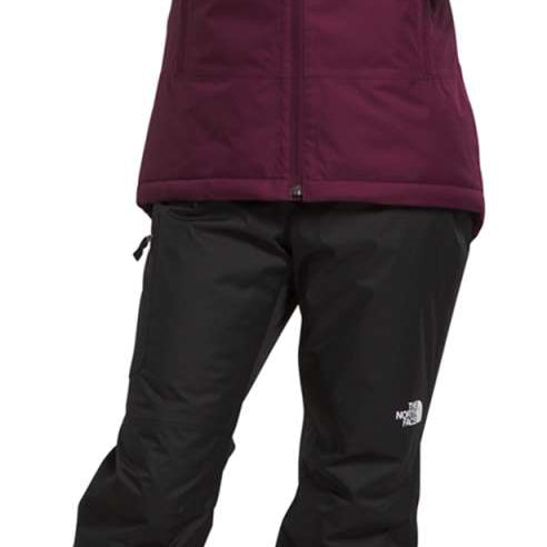 North Face Girls Freedom Insulated Jacket - A young girl wearing a purple jacket with a hood, zipped up to her neck.
