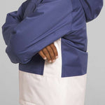 North Face Girls Freedom Insulated Jacket - A young girl with curly brown hair is wearing a blue and white jacket, posing in front of a light gray background.