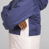 North Face Girls Freedom Insulated Jacket - A young girl with curly brown hair is wearing a blue and white jacket, posing in front of a light gray background.