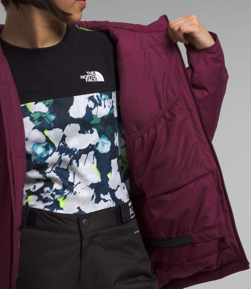 North Face Girls Freedom Insulated Jacket - A dark-colored, insulated jacket with a prominent white logo on the chest and a zipper running down the front.
