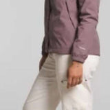 North Face Ladies Antora Triclimate Shell Jacket 2024 - A woman with curly brown hair wearing a purple jacket, white pants and green sneakers is shown from the side.