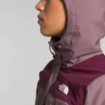 North Face Ladies Antora Triclimate Shell Jacket - A woman wearing a purple and grey jacket with a white logo on the left chest area, standing in front of a light gray background.