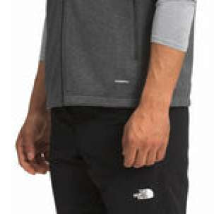 North Face Apex Canyonwall Vest - A dark gray fleece vest with zippered pockets and a high collar, worn by a model on a plain background.