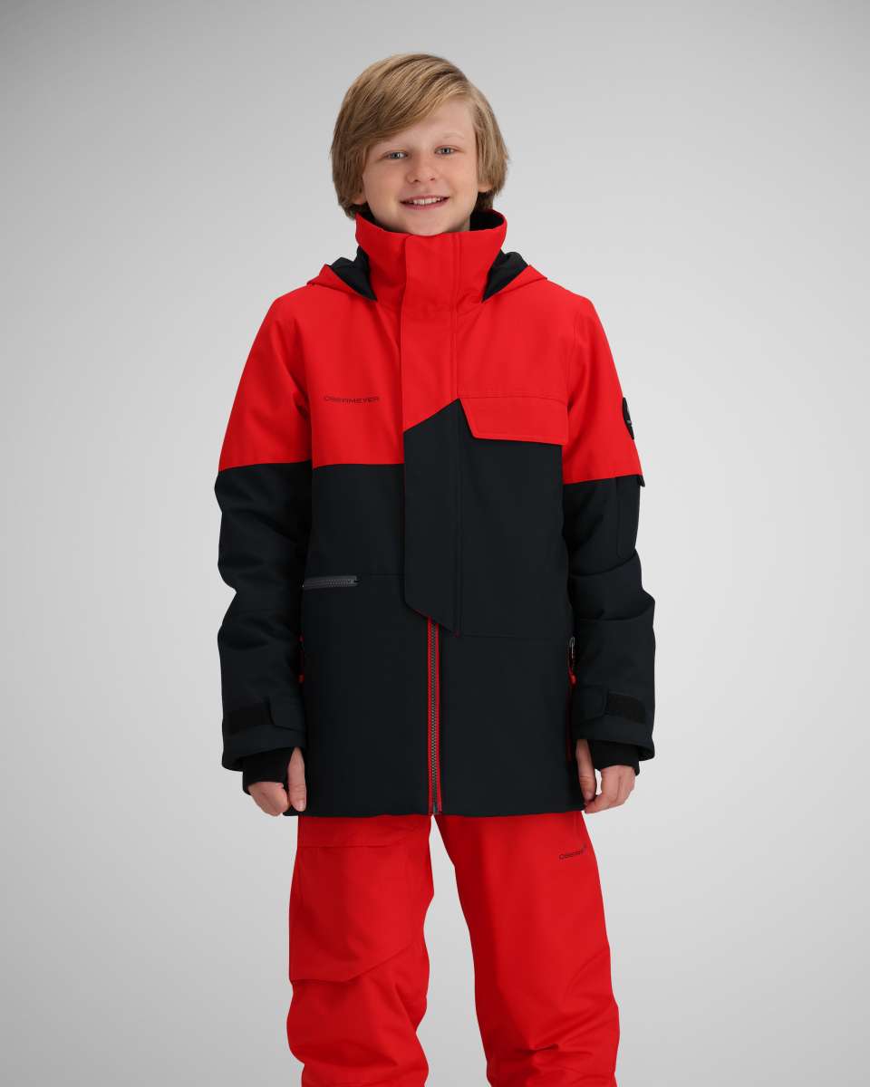 Obermeyer Juniors Axel Insulated Jacket 2024 - A red and black insulated jacket with a high collar, zippered pockets, and a snow skirt.