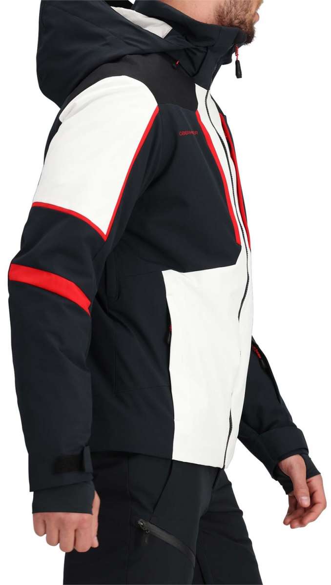 Obermeyer Foundation Insulated Jacket Tall 2024 - A black and white insulated jacket with red trim, worn by a model from the side.