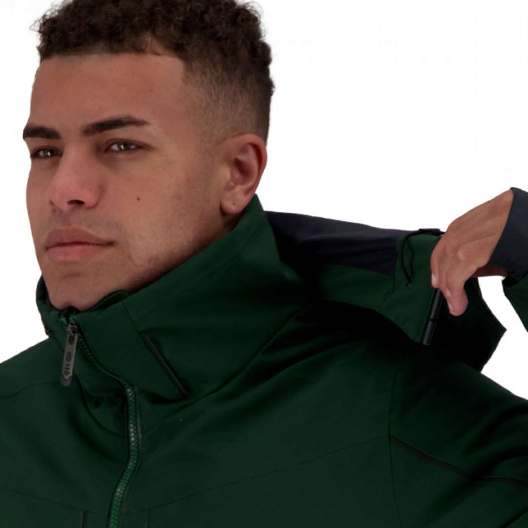 Obermeyer Kodiak Jacket 2022 - A dark green jacket with a high collar and zippered pockets, worn by a man with short curly hair looking to his left.