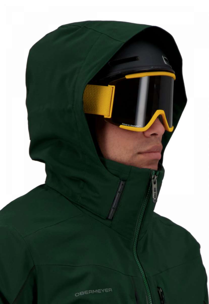 Obermeyer Kodiak Jacket 2022 - A dark green ski jacket with a hood, featuring a zippered front and two zippered pockets on the chest.