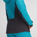 Obermeyer Women's Cosima Down Jacket - A bright blue down jacket with a high collar and zippered pockets, worn by a model facing left.