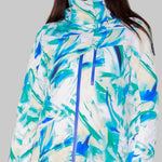 Obermeyer Women's Jette Insulated Jacket 2022-2023 - A white jacket with a blue and green abstract pattern, featuring a high collar and zippered pockets.